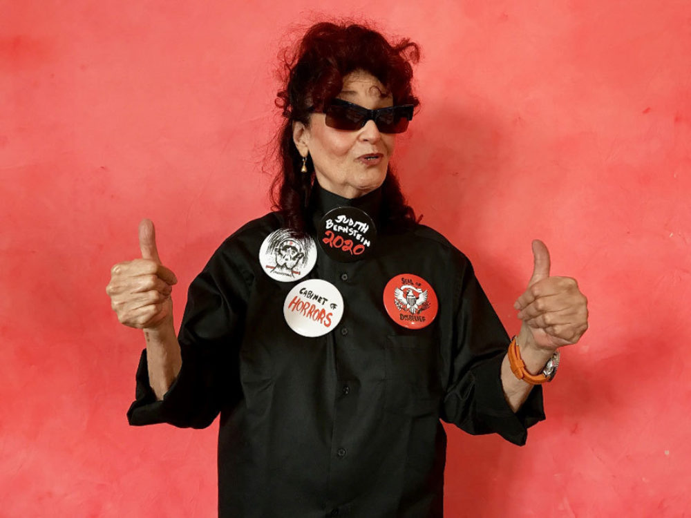 Judith Bernstein wearing her pins made for Cabinet of Horrors